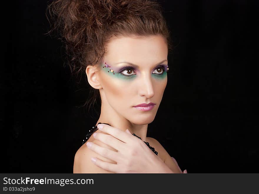 Portrait of young woman with creative make-up on black