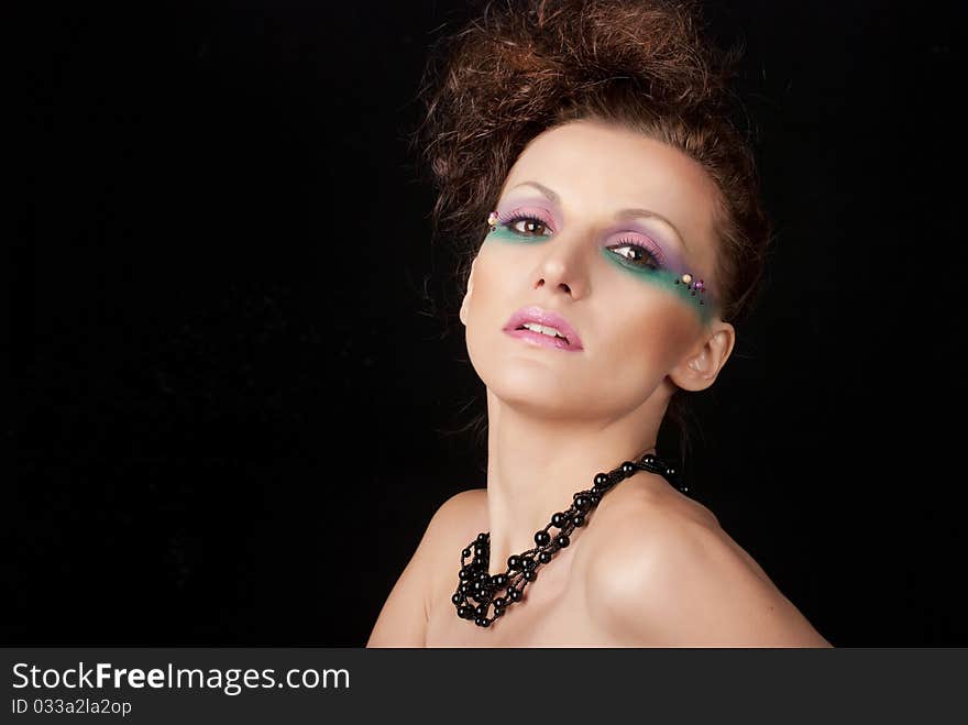 Portrait of young woman with creative make-up on black