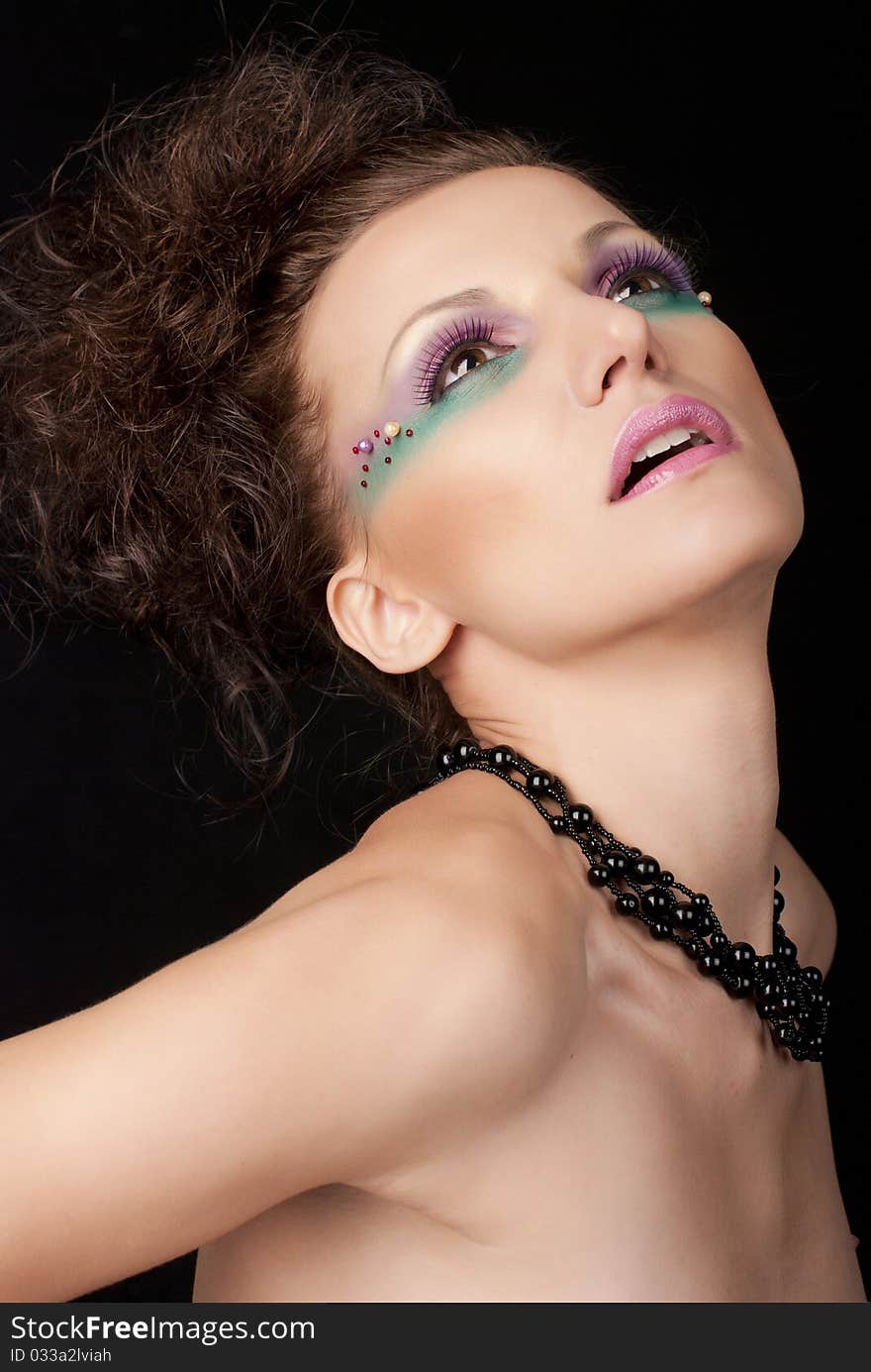 Portrait of young woman with creative make-up on black