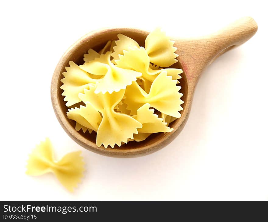 Farfalle pasta in a wooden cup on white background