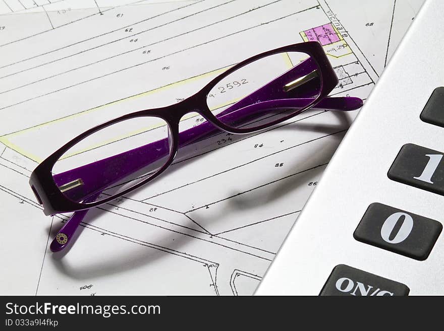 Calculator and eyeglasses with technical drawings. Calculator and eyeglasses with technical drawings