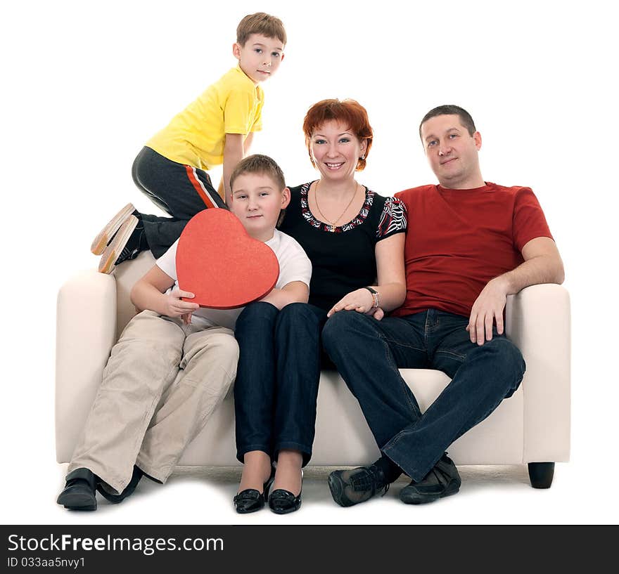 Family silit on the couch in the hands of a red decorative heart