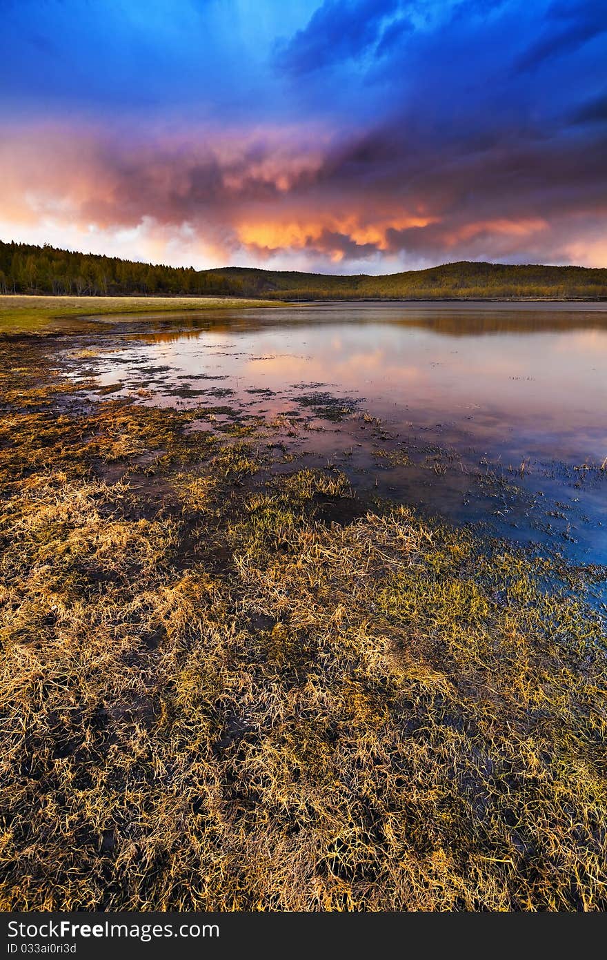 Sunset under the lake and forest