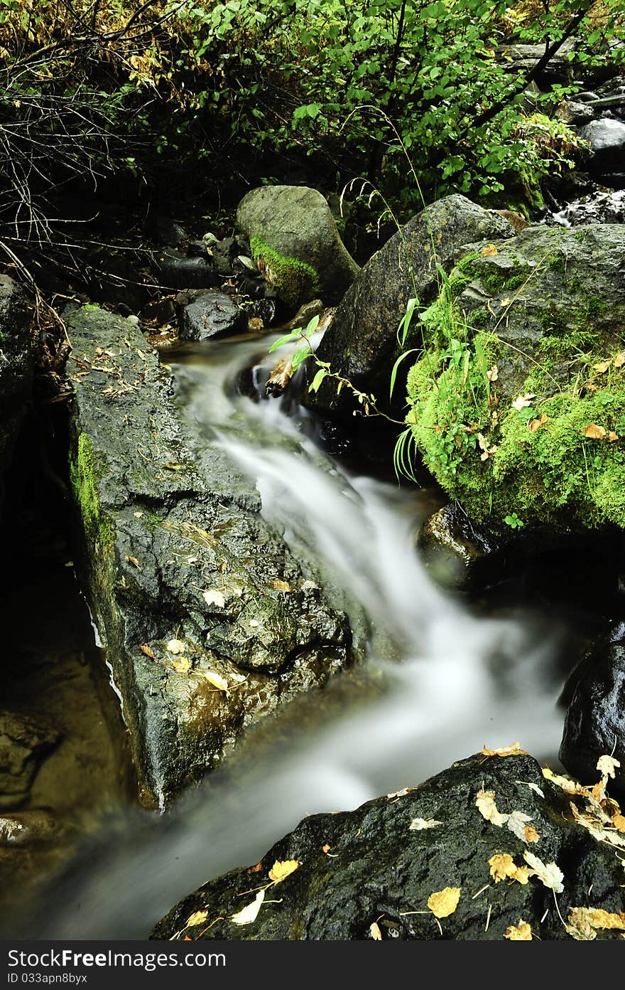 A slow moving creek cascading down granite rocks