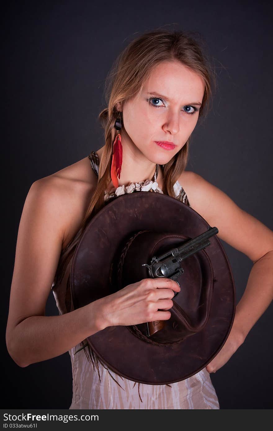 The American Indian girl with a cowboy's hat holds a pistol