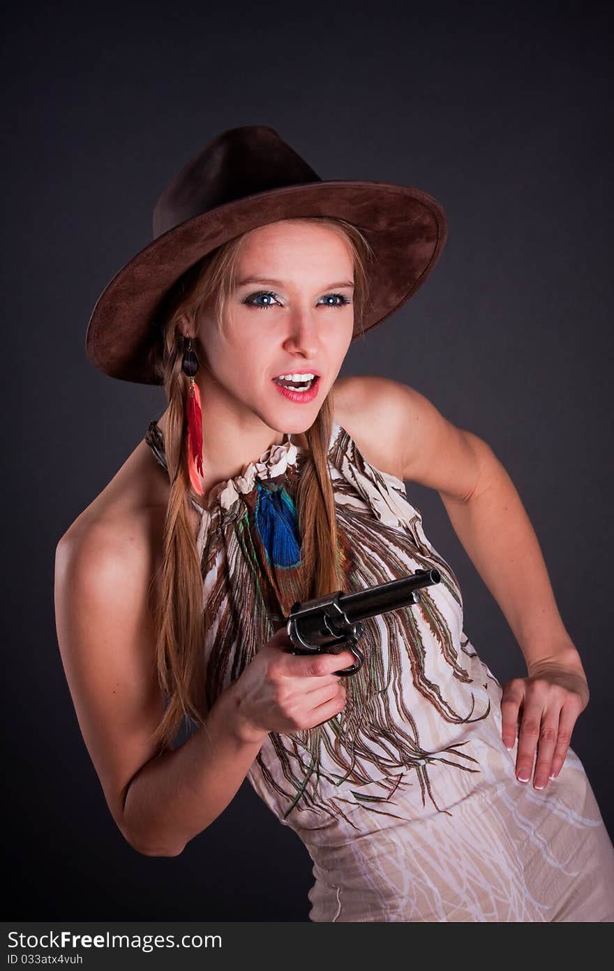 The American Indian girl in a cowboy's hat holds a pistol