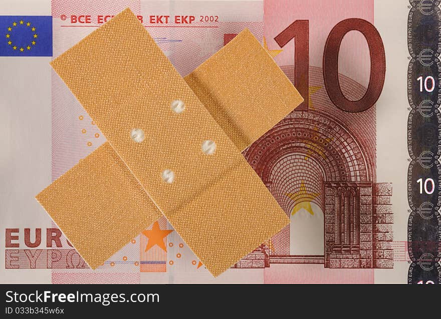 Euro banknote and medical wound bandage as symbol for costs at health care. Euro banknote and medical wound bandage as symbol for costs at health care