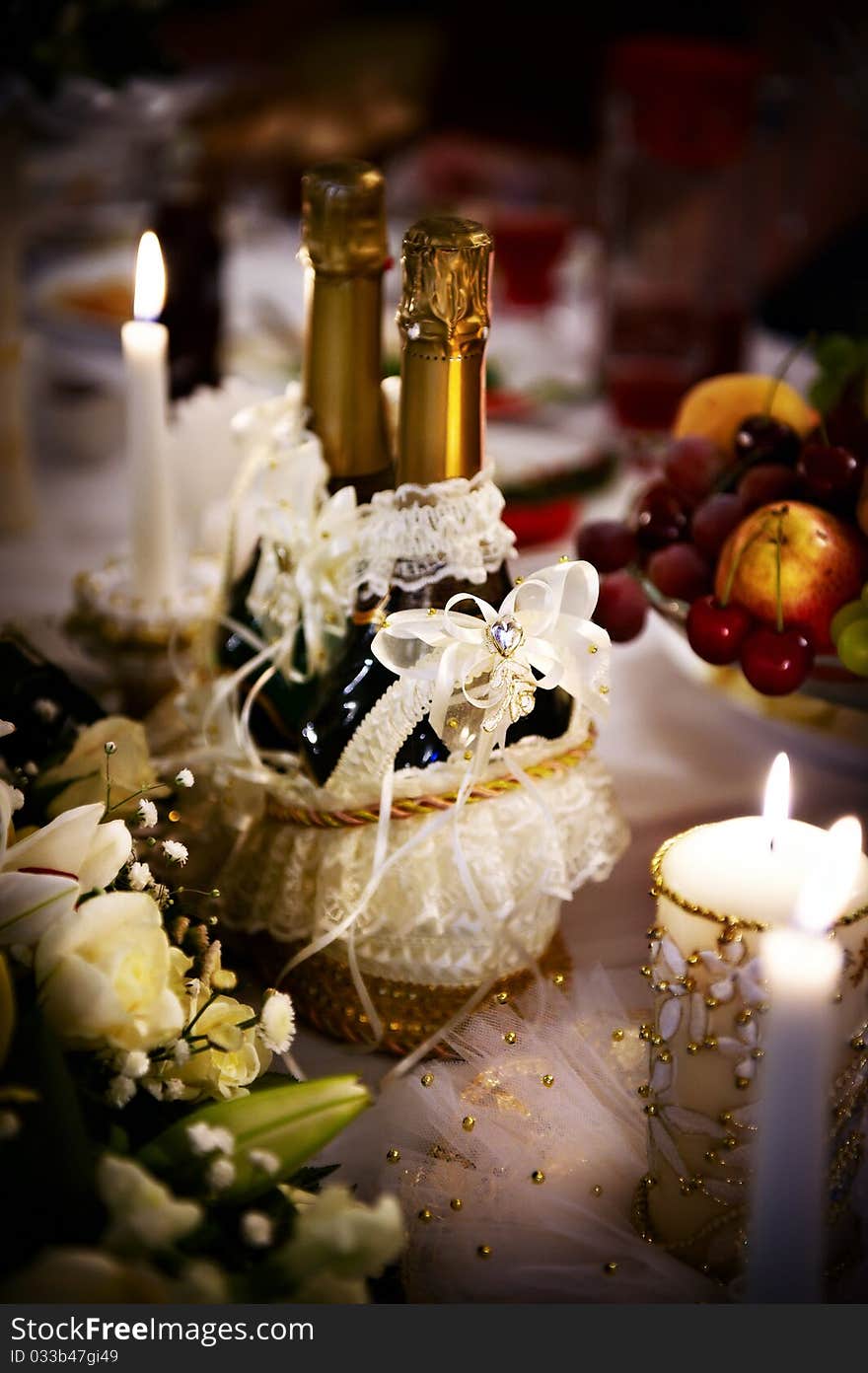 Bottle of champagne and candles on wedding table