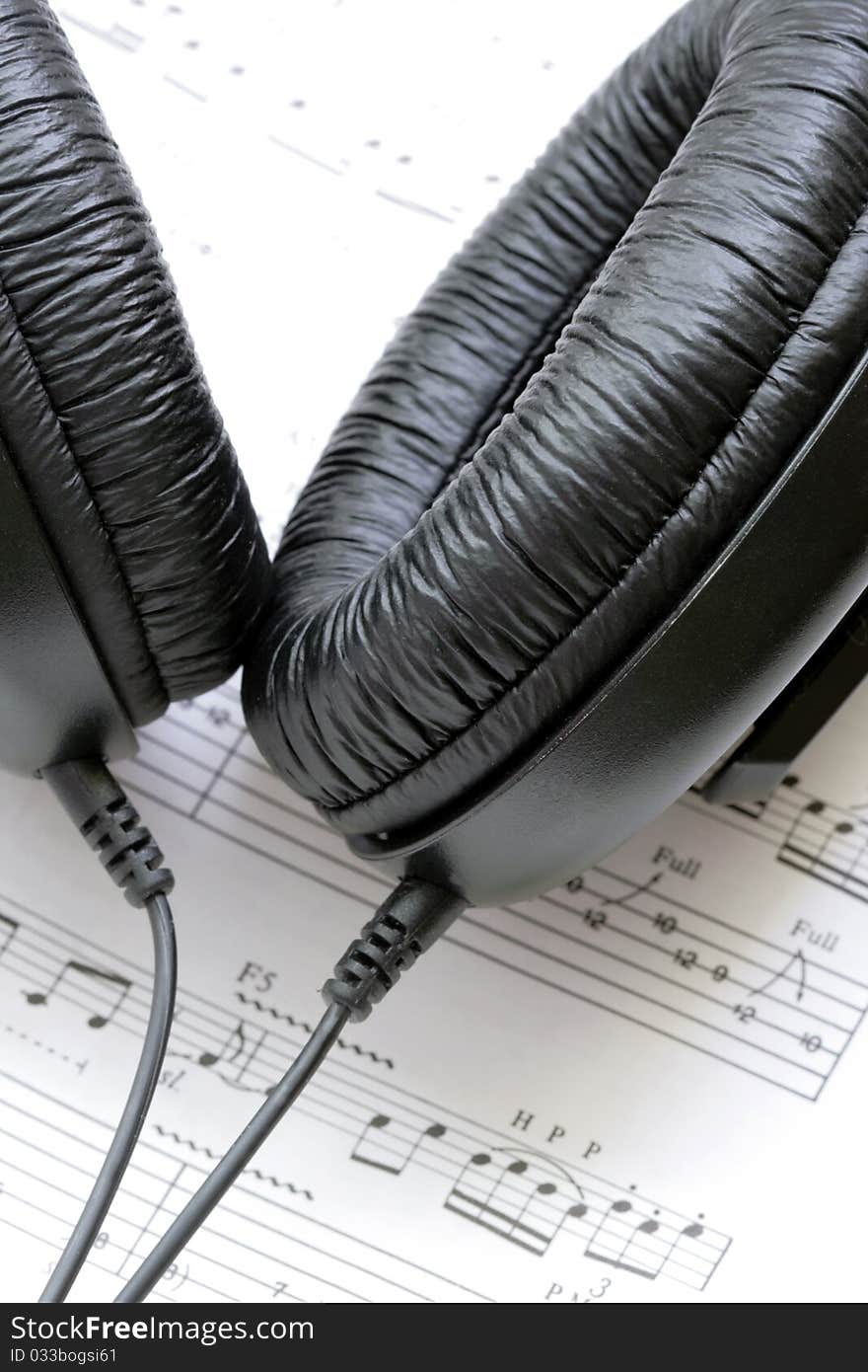 Black earphones with notes in background