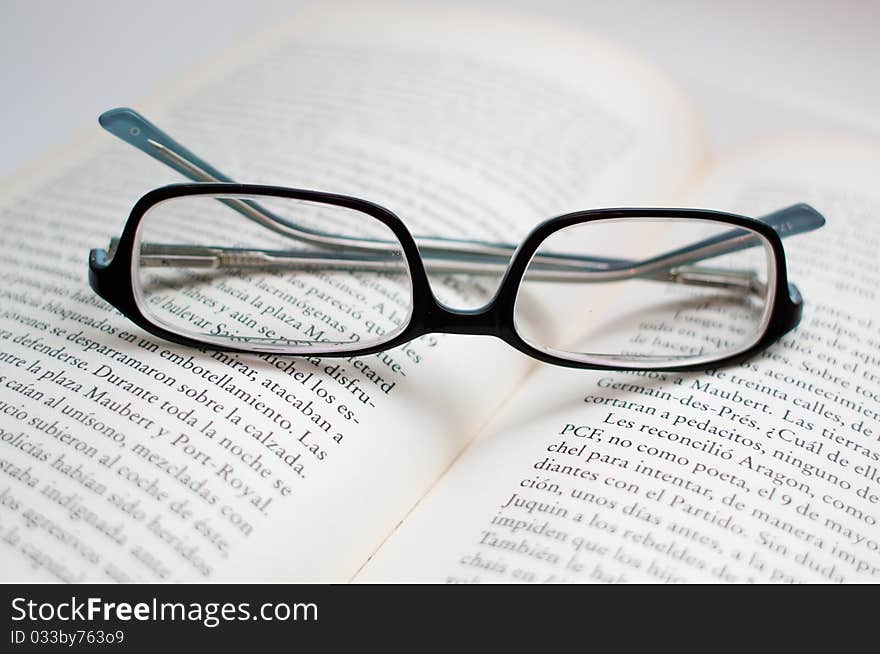 Glasses over a book, symbolizing education, reading.