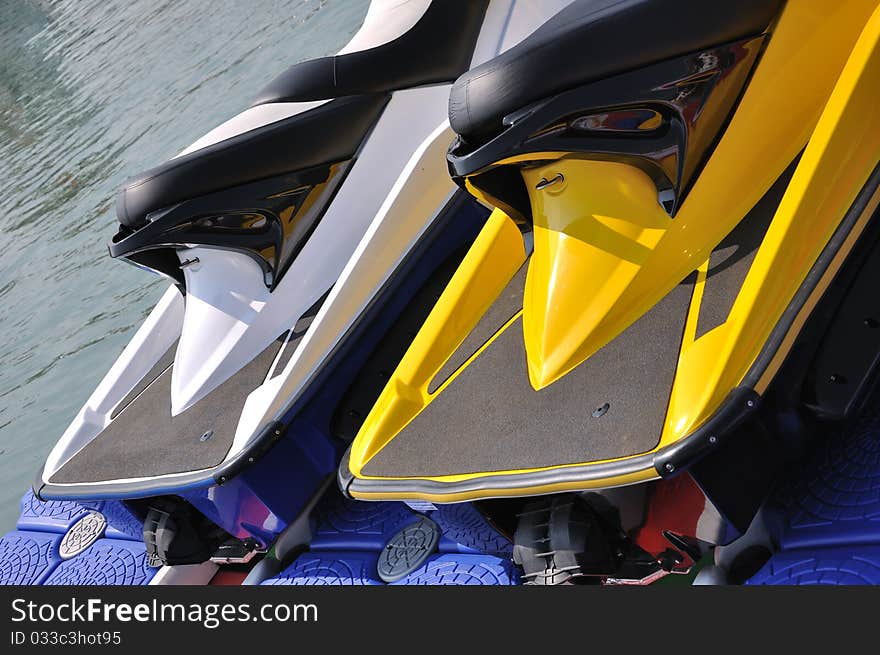 Part of two motor boat body in yellow and white color, beside water, shown as water sport or holiday and entertainment. Part of two motor boat body in yellow and white color, beside water, shown as water sport or holiday and entertainment.