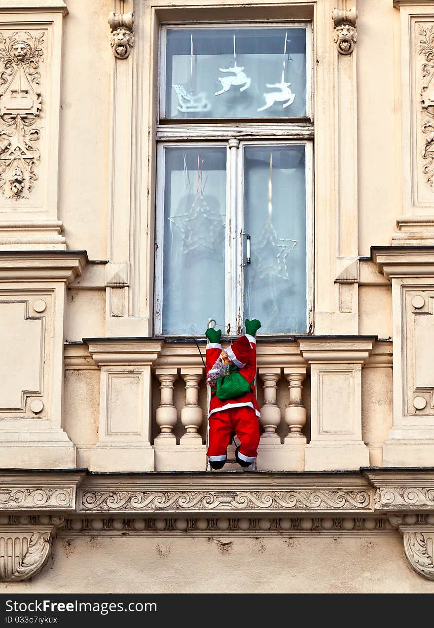 Santa claus is climbing up a historic facade. Santa claus is climbing up a historic facade