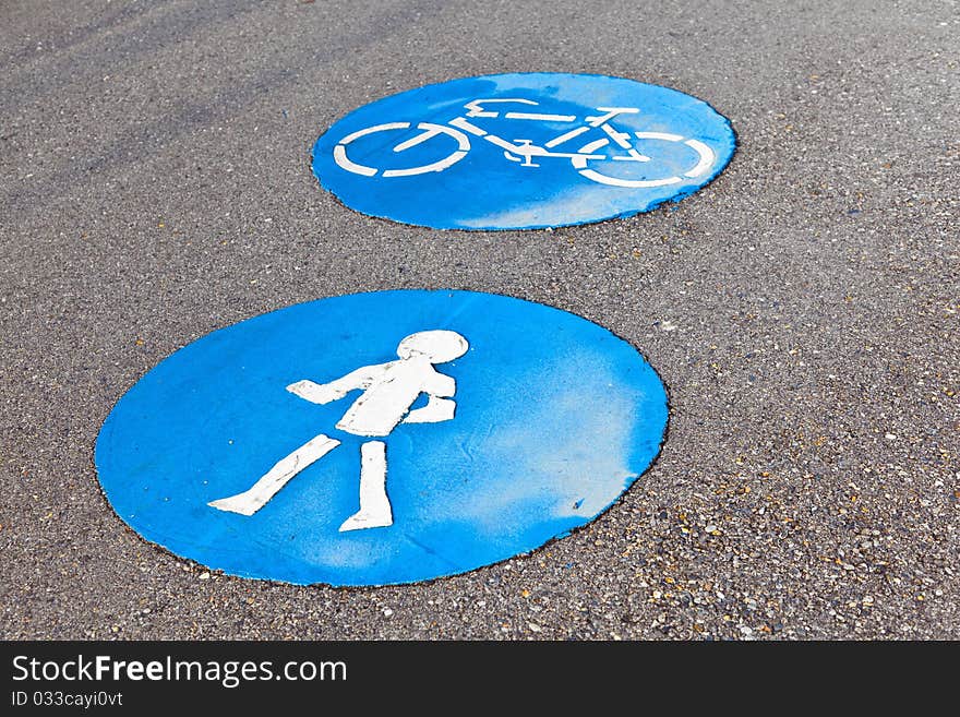 Symbol for pathway and icon for pedestrians on asphalt