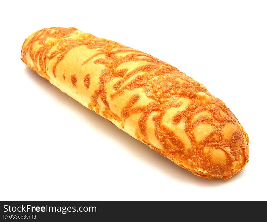 The ruddy long loaf of bread is strewed by cheese isolated on a white background