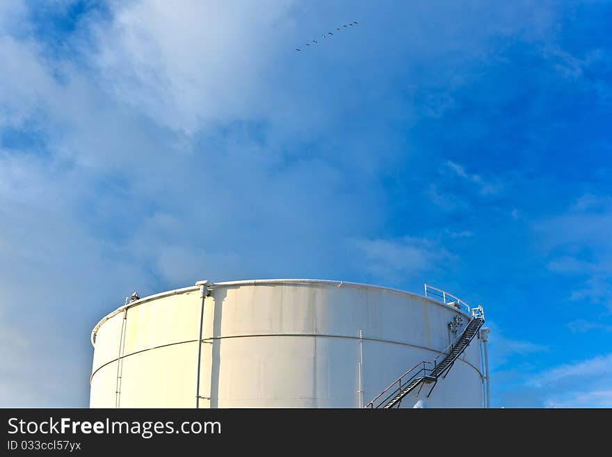 White tanks in tank farm with iron staircase in snow. White tanks in tank farm with iron staircase in snow