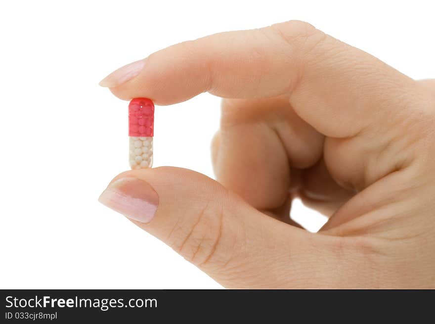 Hand with a pill on white background