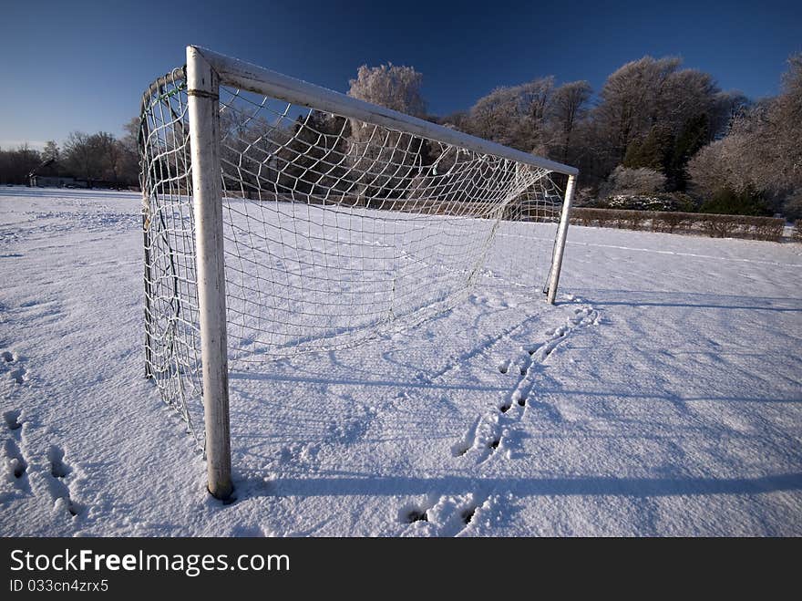 Soccer goal and field in winter snow. No green grass.