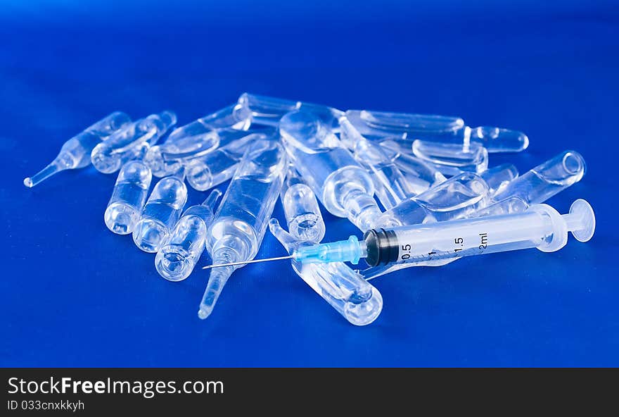 Vials and a syringe on a blue background