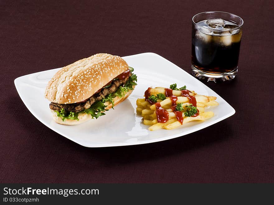 Ribeye steak in sesame seed bun with fries and coke. Ribeye steak in sesame seed bun with fries and coke