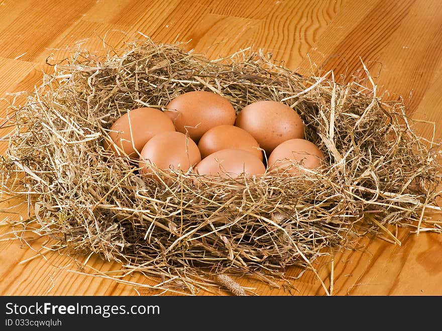 Fresh farm eggs in hay on wooden table. Fresh farm eggs in hay on wooden table