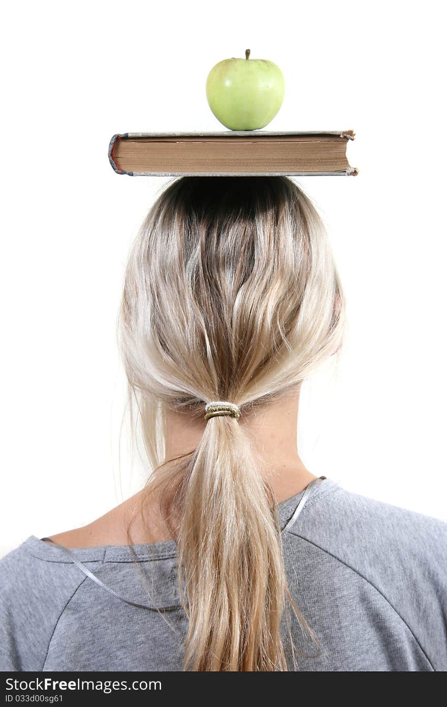 student with apple and book on the head