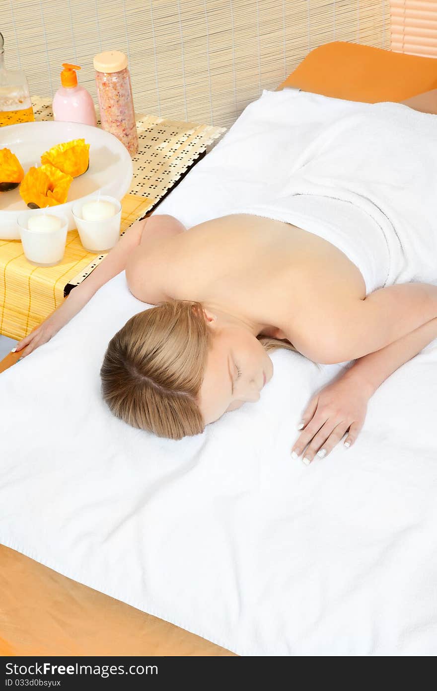 Woman in spa on white towel with blond hair