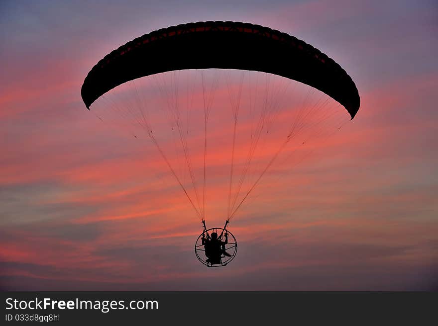 Paramotor flying against dramatic sky. Paramotor flying against dramatic sky