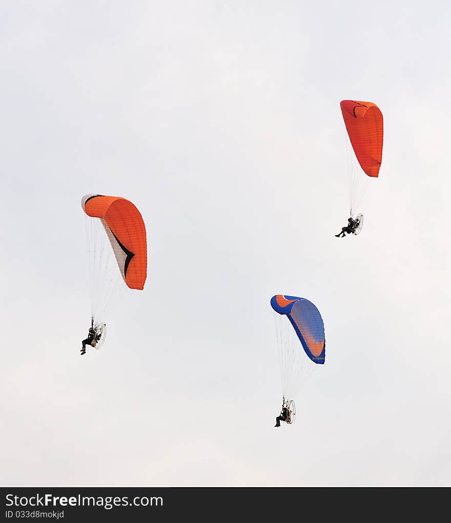 Two Paramotors flying against blue sky