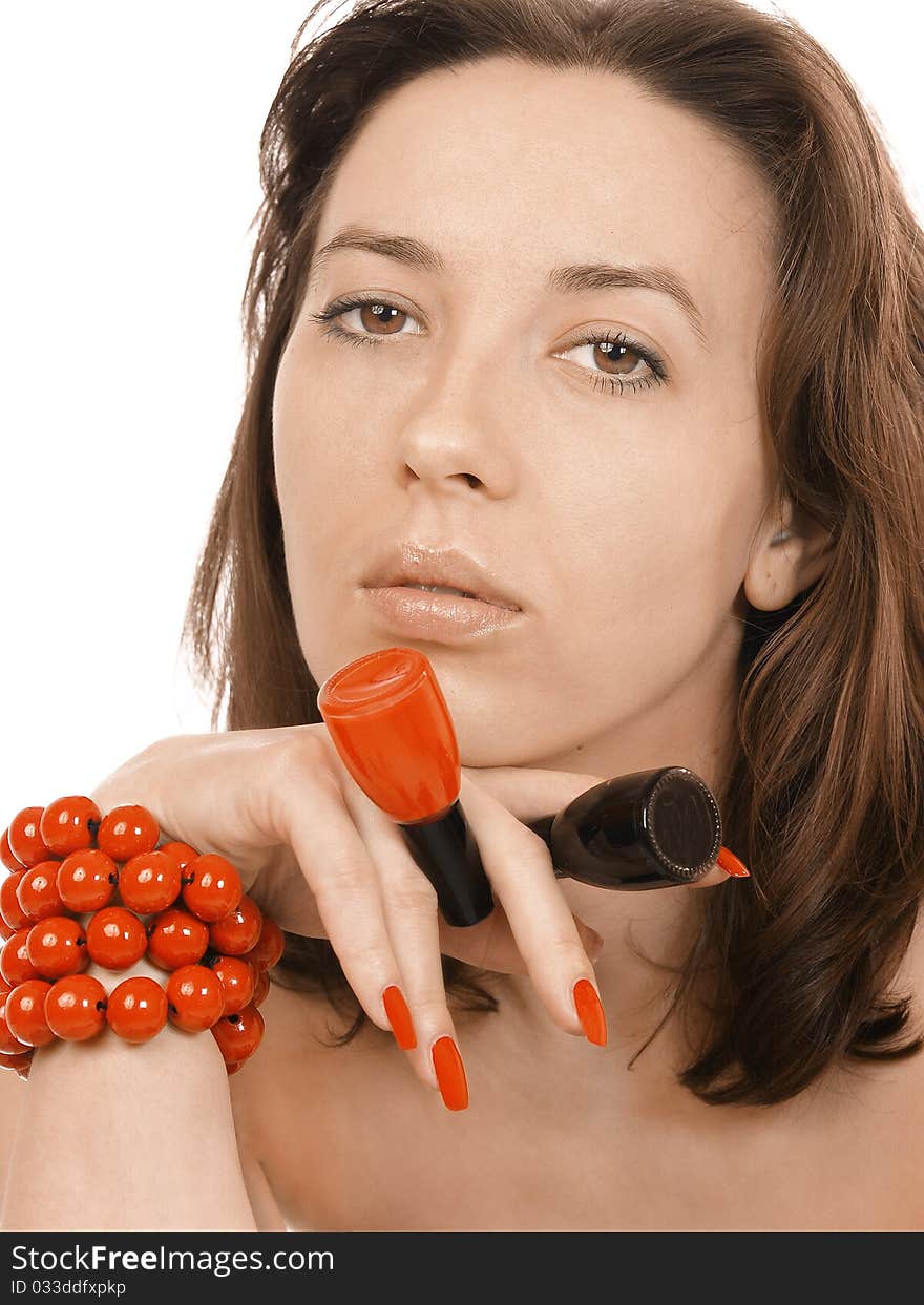 Girl in a red beads holds nail polish. Girl in a red beads holds nail polish