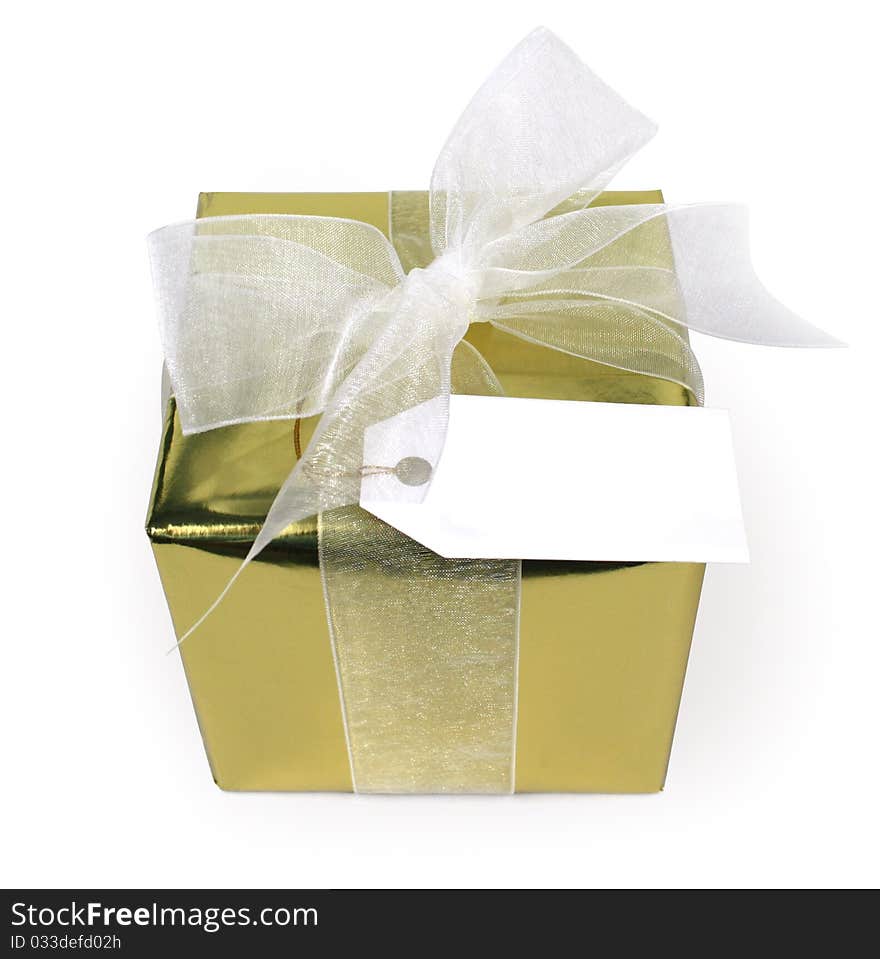 A shiny gold gift with a white bow and tag isolated on white. A shiny gold gift with a white bow and tag isolated on white.