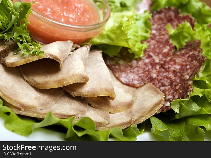 Appetizer made of meat delicacies and salad. Appetizer made of meat delicacies and salad