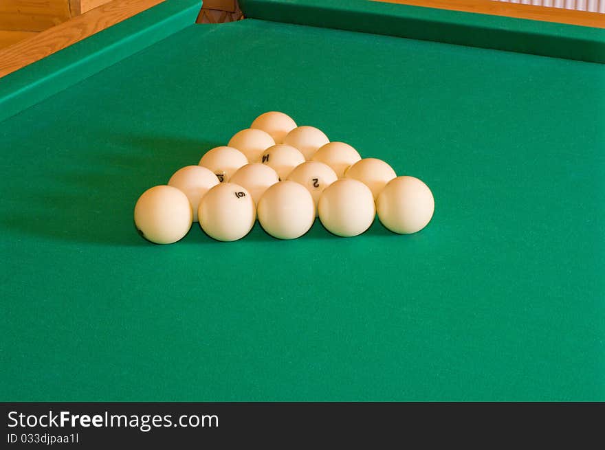 Triangle of balls for Russian billiards on a table with green baize. Triangle of balls for Russian billiards on a table with green baize.