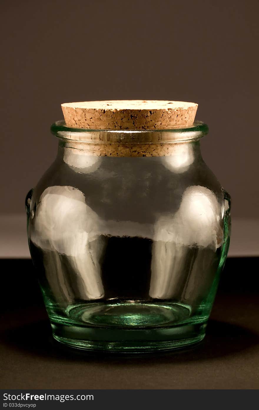 Close view detail of a glass jar isolated on a dark background.