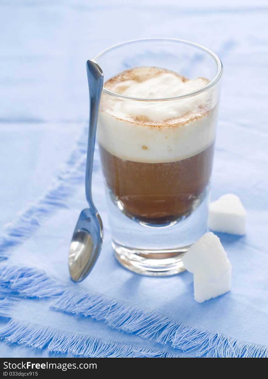 Cafe Latte in glass with spoon and sugar on plate. Cafe Latte in glass with spoon and sugar on plate