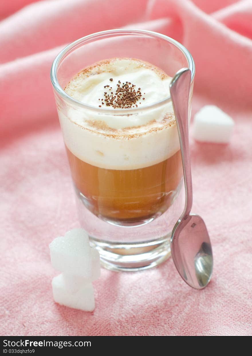 Cafe Latte in glass with spoon and sugar on plate. Cafe Latte in glass with spoon and sugar on plate