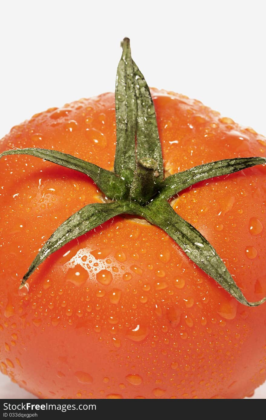 Close view detail of a red tomatoe isolated on a white background.