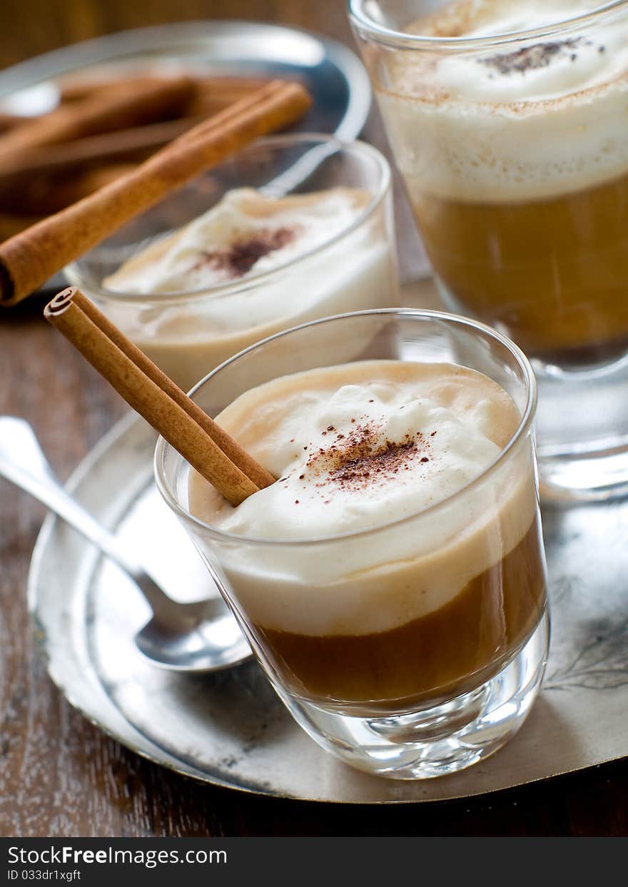 Cafe Latte in glasses with cinnamon stick on plate. Cafe Latte in glasses with cinnamon stick on plate