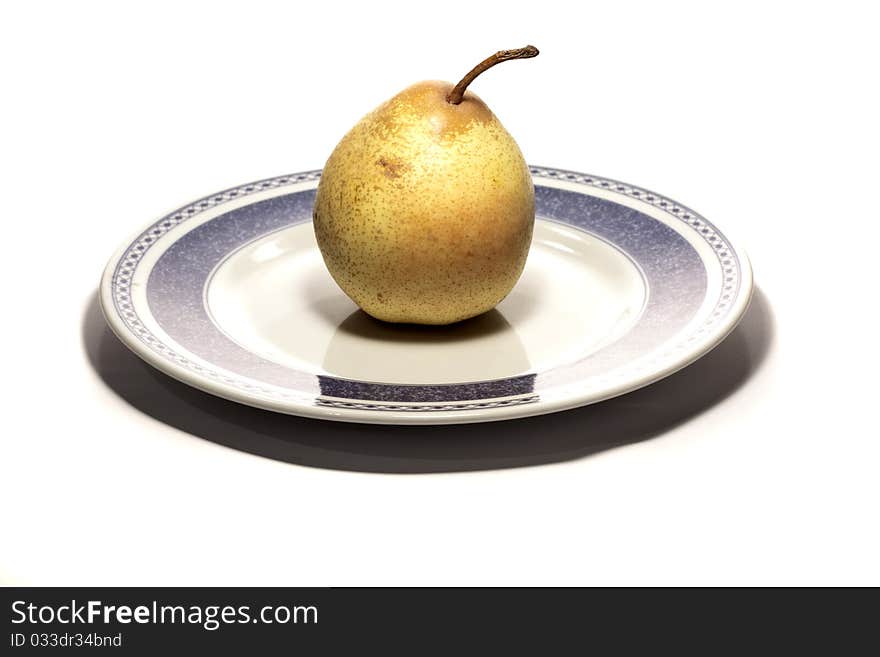 Close view detail of a pear on a plate isolated on a white background.