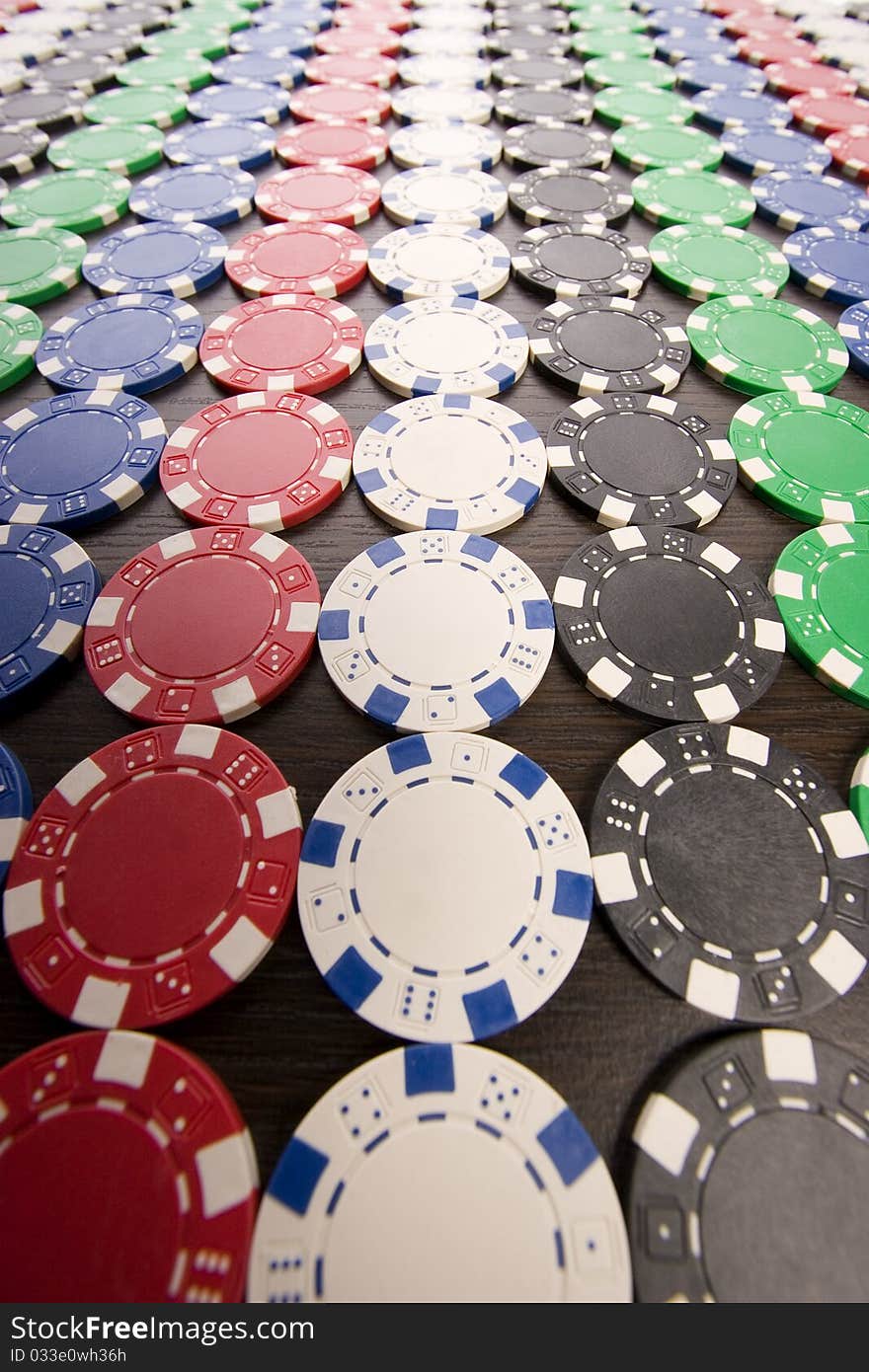 Multi - colored gambling chips on a background. Multi - colored gambling chips on a background