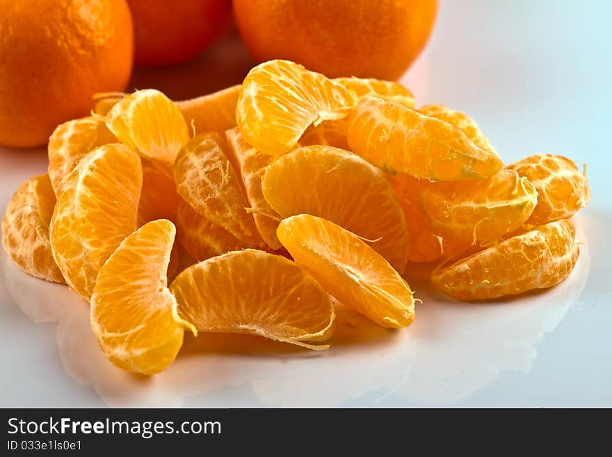 Peeled clementine and hole clementines on white surface. Peeled clementine and hole clementines on white surface