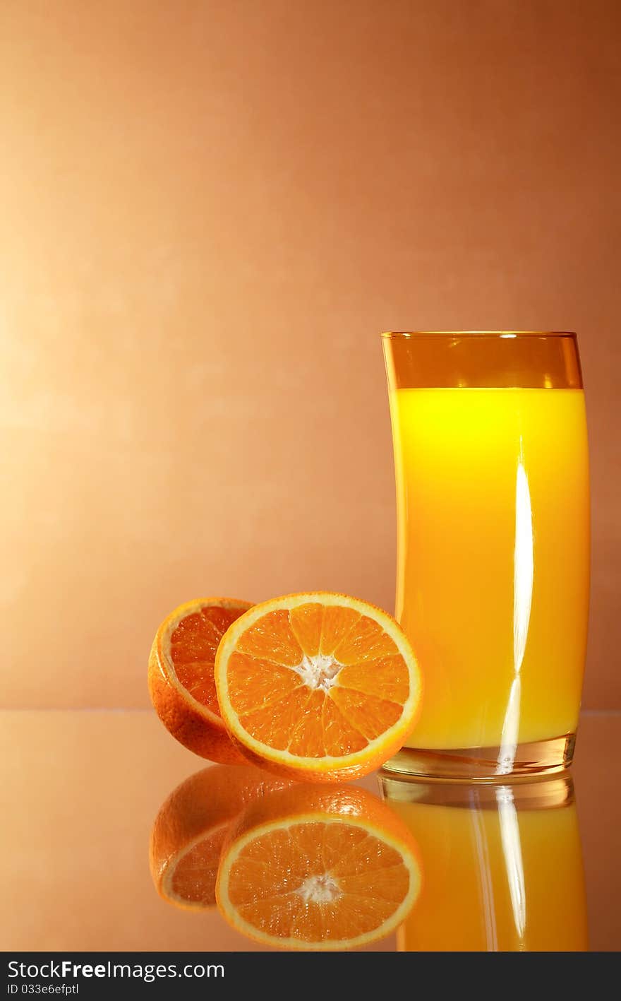 Sliced oranges near glass of orange juice on gradient background with reverberation