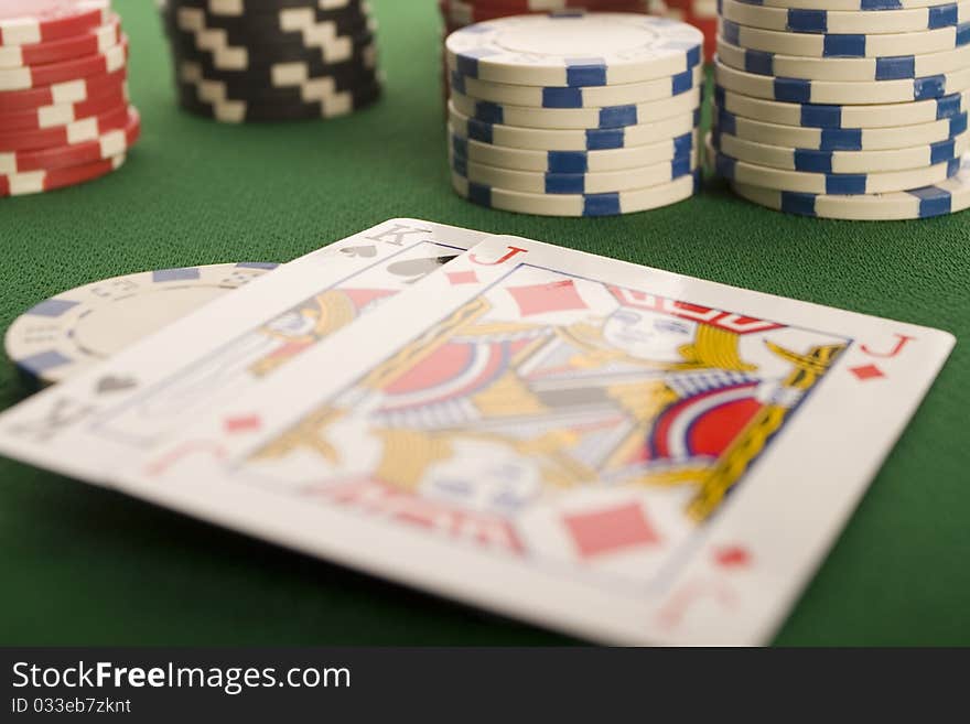 Close-up of Poker cards and gambling chips on green background. Close-up of Poker cards and gambling chips on green background