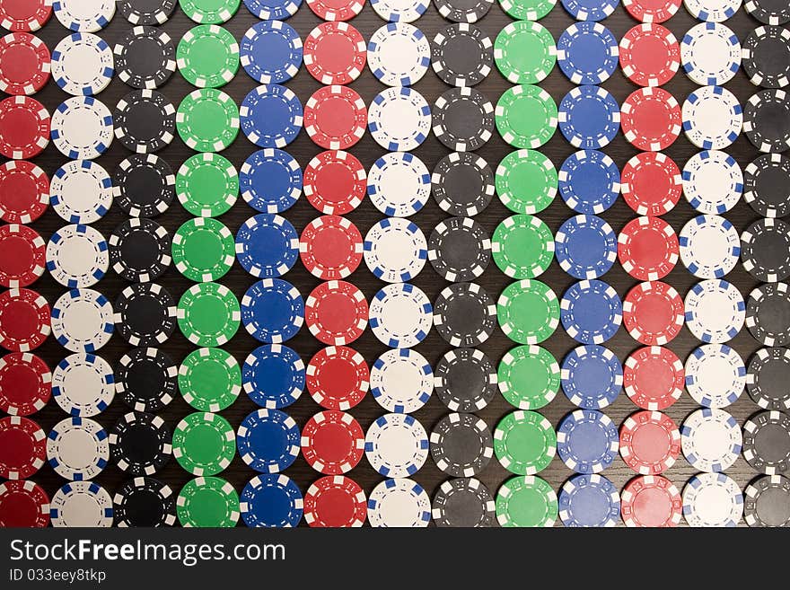 Multi - colored gambling chips on a background. Multi - colored gambling chips on a background