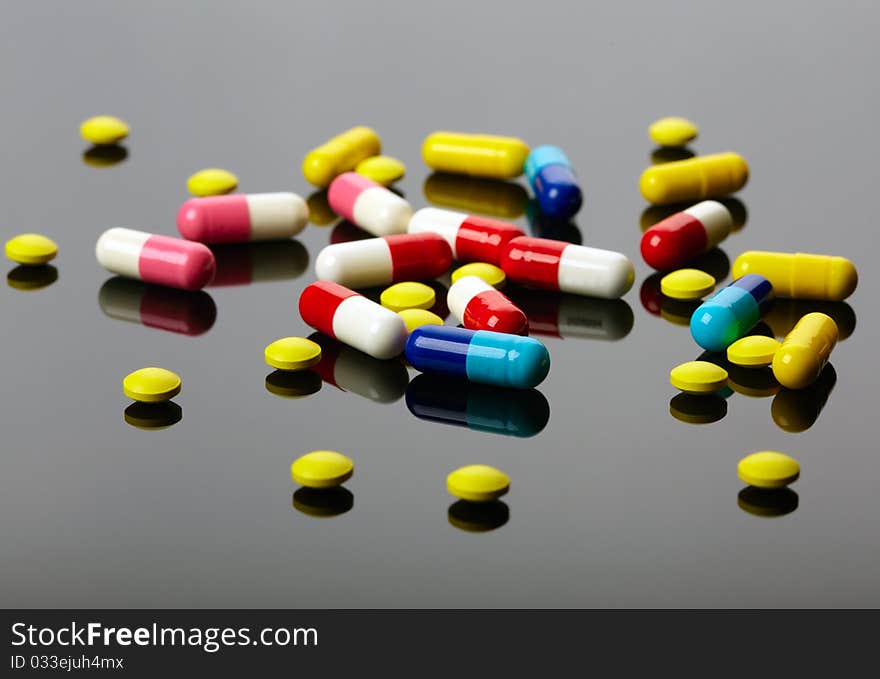 Colorful pills over dark background