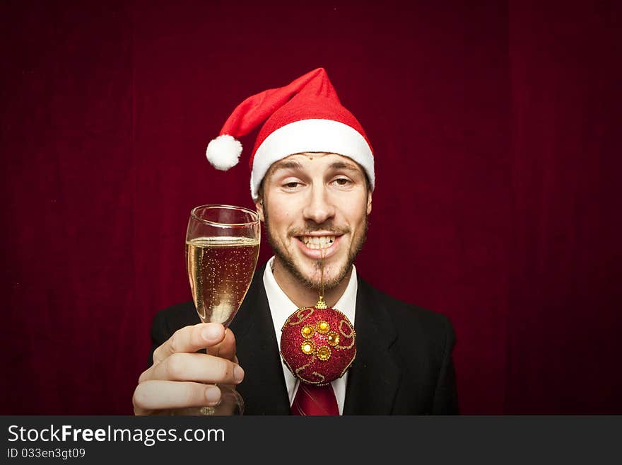 Young funny guy with christmas hat on red velvet background