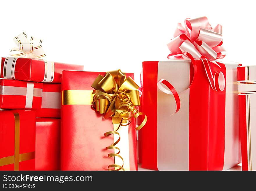 A lot of Christmas presents different values in the red packages with colorful bows. Isolated white background. A lot of Christmas presents different values in the red packages with colorful bows. Isolated white background