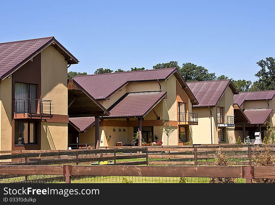 Brown houses with purple rooftops in residential area. Brown houses with purple rooftops in residential area.