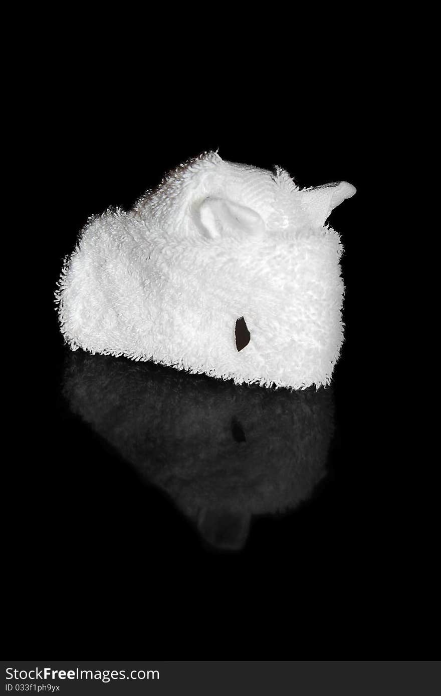 White towel folded into an origami mouse isolated on a black background with a reflection. White towel folded into an origami mouse isolated on a black background with a reflection