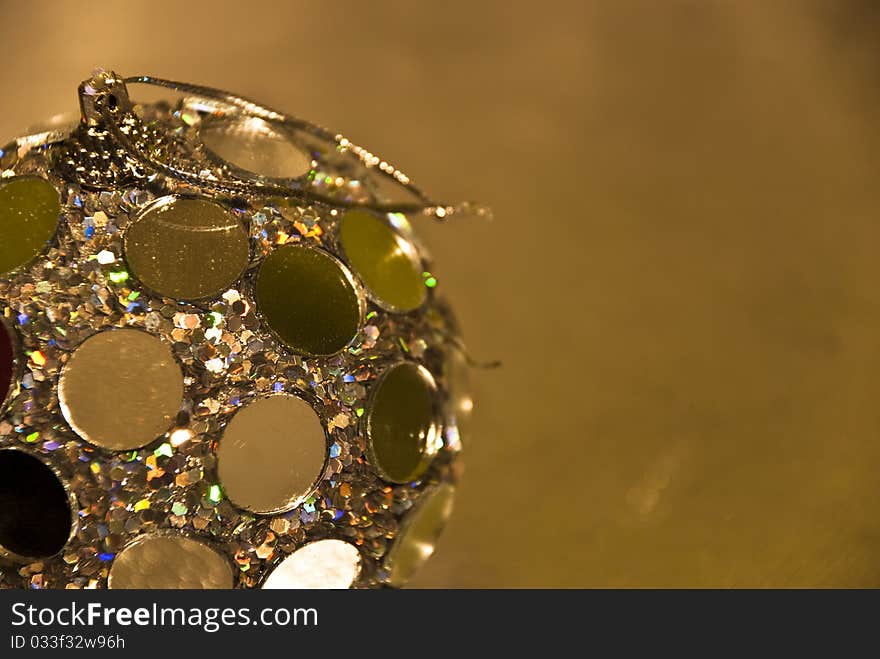 Image of a single golden decoration ball on golden background. Image of a single golden decoration ball on golden background