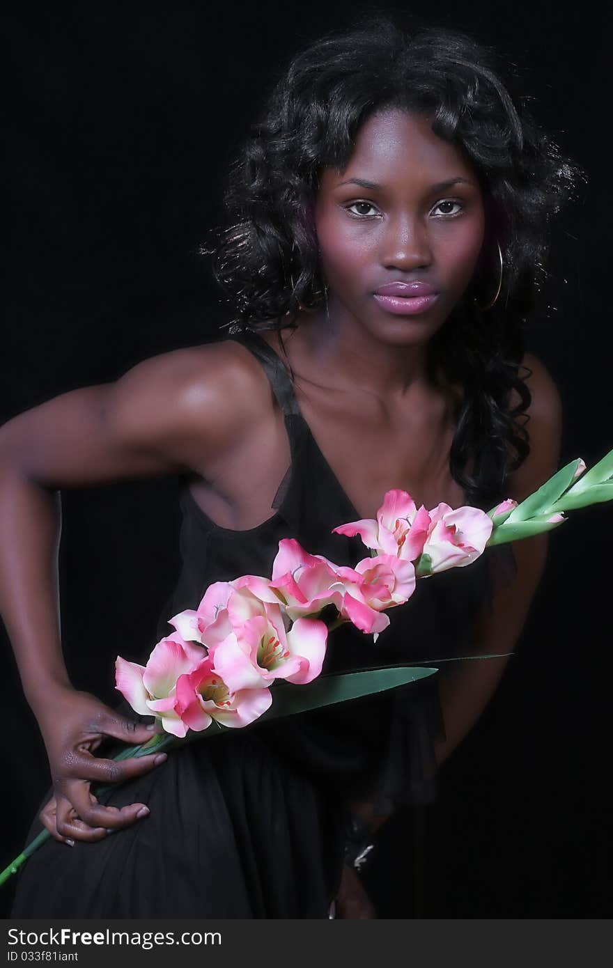 A sexy African American woman with a large flower. A sexy African American woman with a large flower